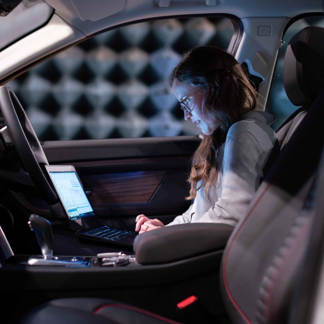 Woman looking at laptop screen in dark room