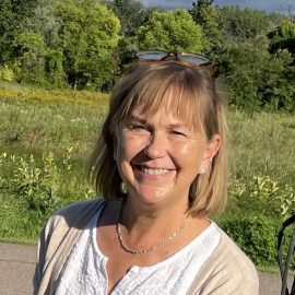photo of author Amy Payne standing in front of a meadow